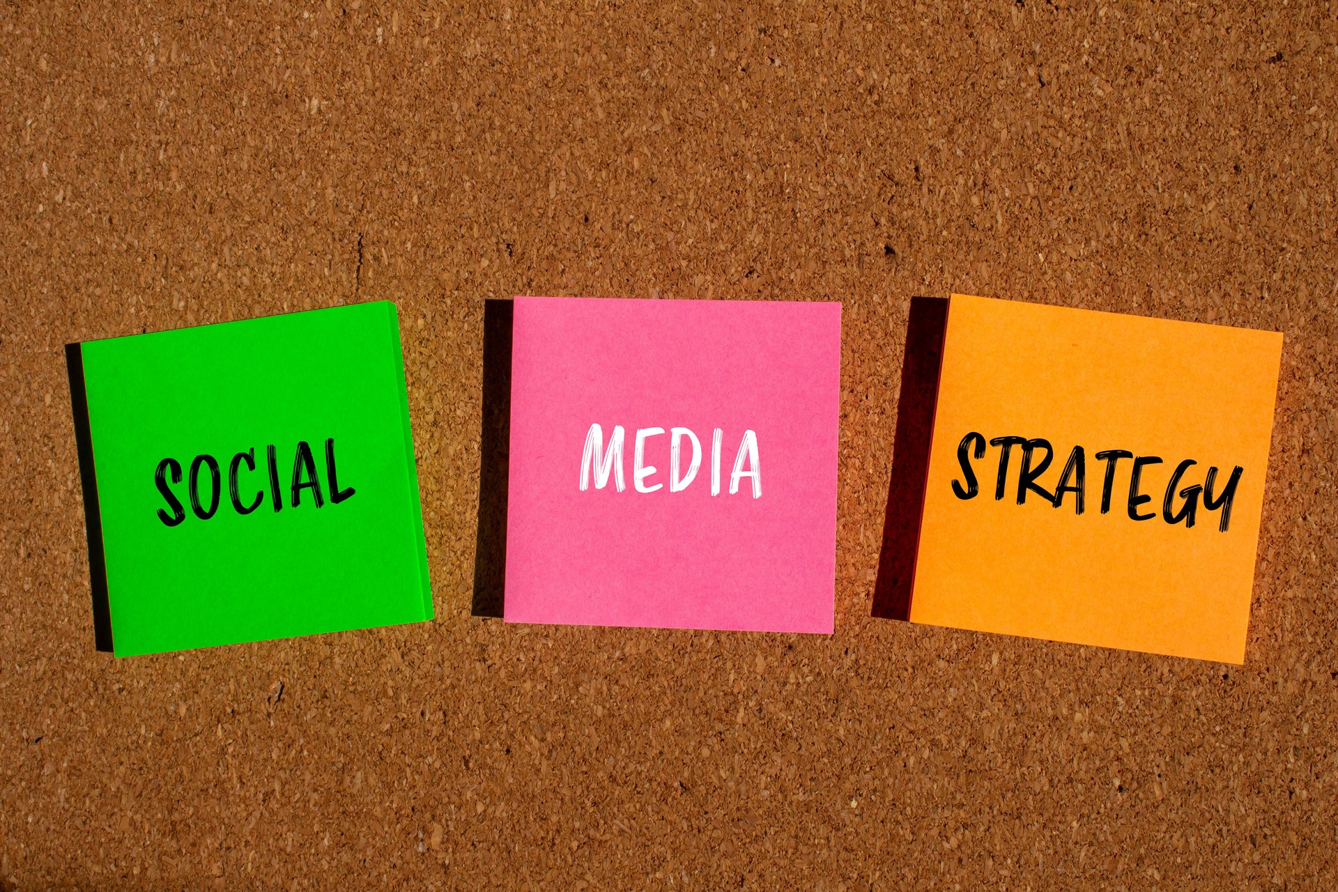 Social media strategy message written on colorful papers with brown background